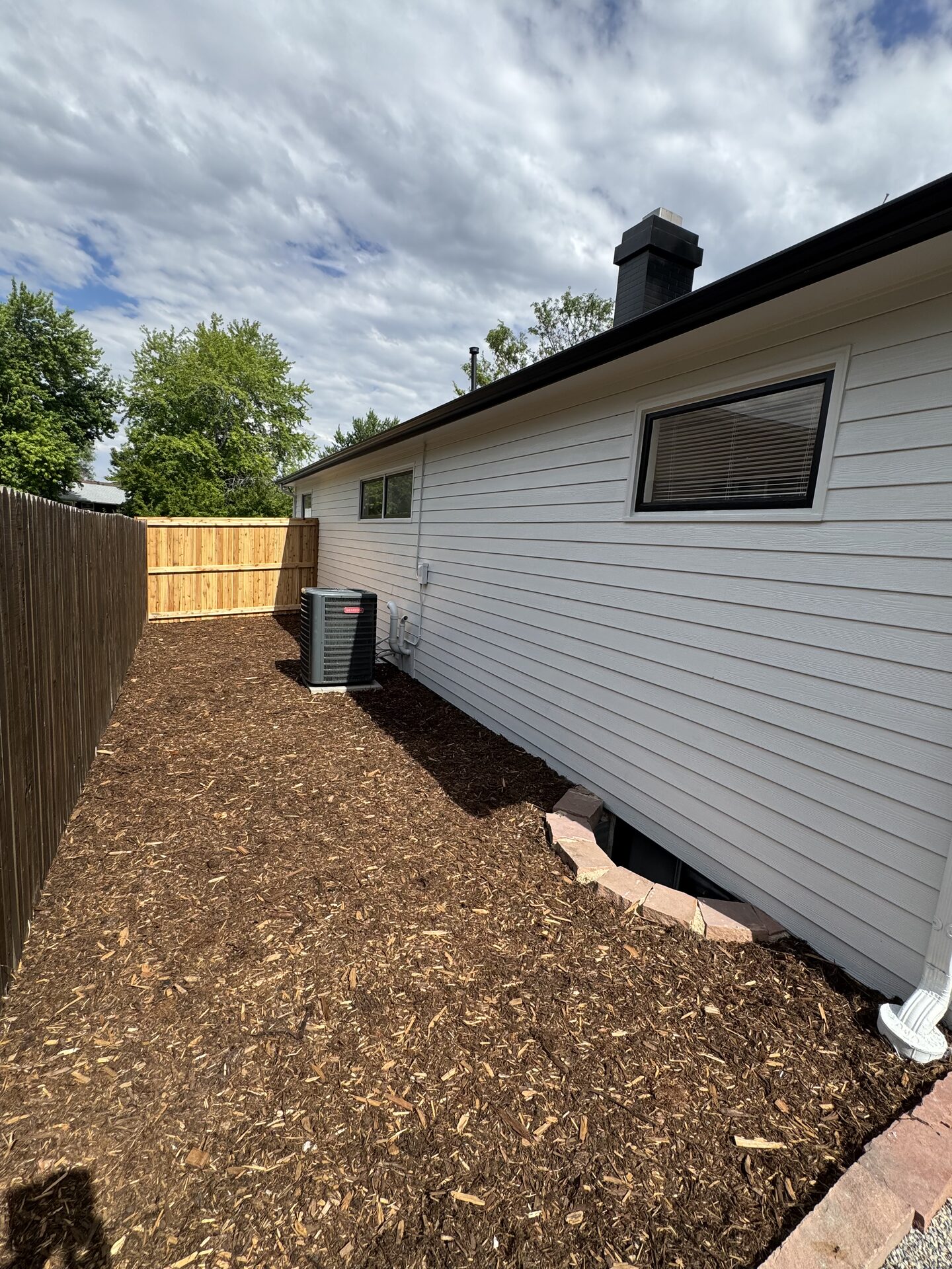 Freshly mulched side yard with fence and clean borders