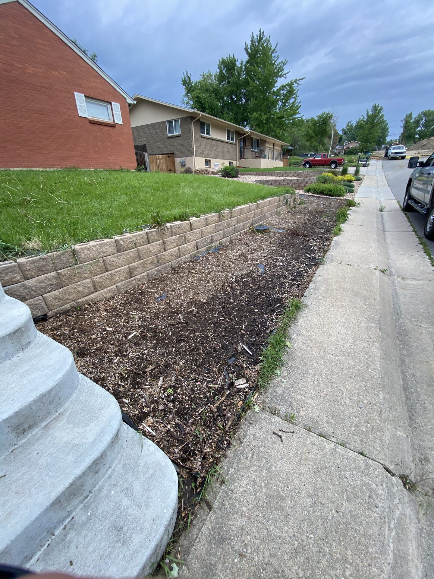Side retaining wall and lawn area before landscape refresh